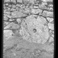 Grindstone set in a wall.