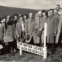 At the start of work on the Avon Dam, officials stand around the planned top water level marker 