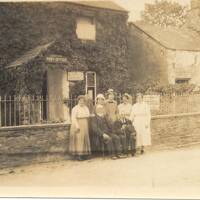 Family group outside the old Post Office in Lydford