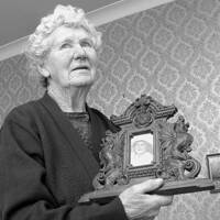 Margaret Burgoyne aged 92 holding photographs of herself aged 5