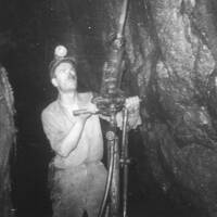 Miner using a compressed-air rock drill at Great Rock Mine