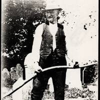Will Gillard with scythe in churchyard, 1930