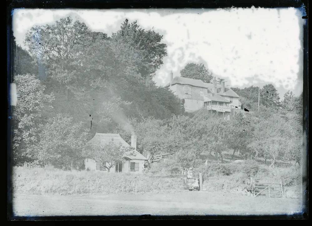 Woman with babe in arms and small child outside a cottage at the rear of Mount Pleasant Inn, Dawlish