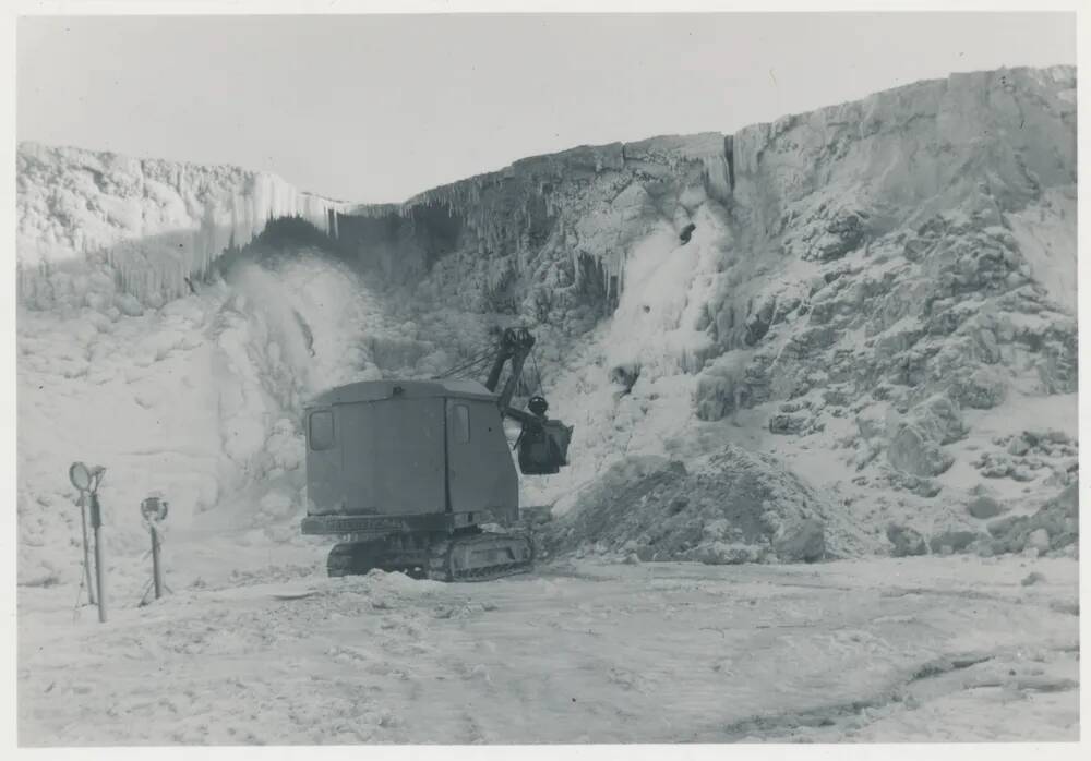 Digger working hard to collect clay during a severe winter