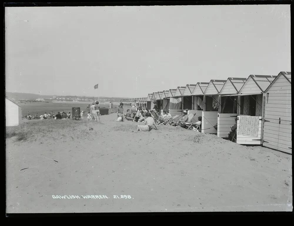 Families enjoying the seaside outside their beach huts near Dawlish Warren