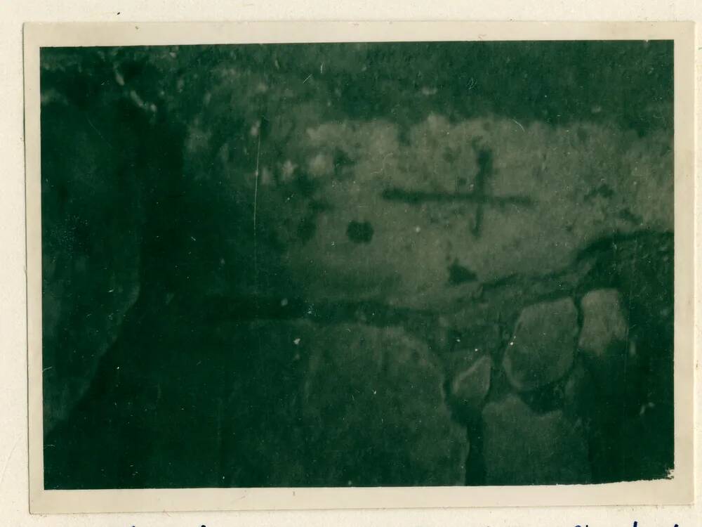 Stone step in outhouse with a cross carved into it.